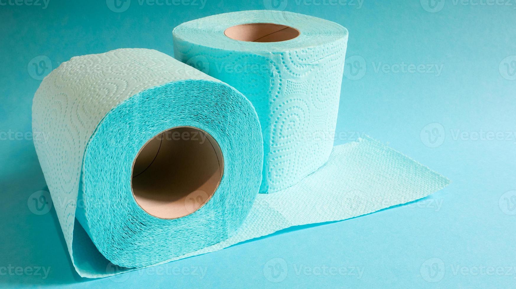 blauwe rol modern toiletpapier op een blauwe achtergrond. een papieren product op een kartonnen hoes, gebruikt voor sanitaire doeleinden van cellulose met uitsparingen om gemakkelijk te scheuren. reliëf tekening foto