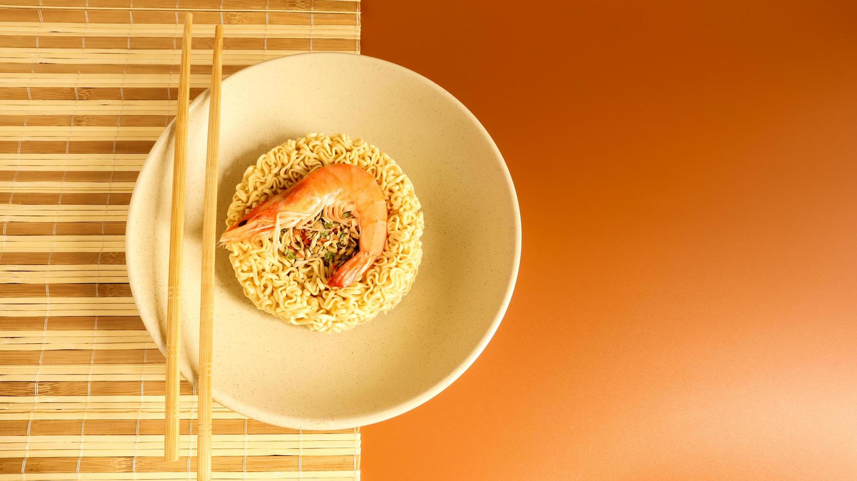 pittige instant noedelsoep met garnalen. garnalensoep, koken, eten. rauwe gedroogde cirkelvormige vermicelli in een bord. Aziatisch eten. pasta, voor de bereiding waarvan het voldoende is om kokend water te gieten foto