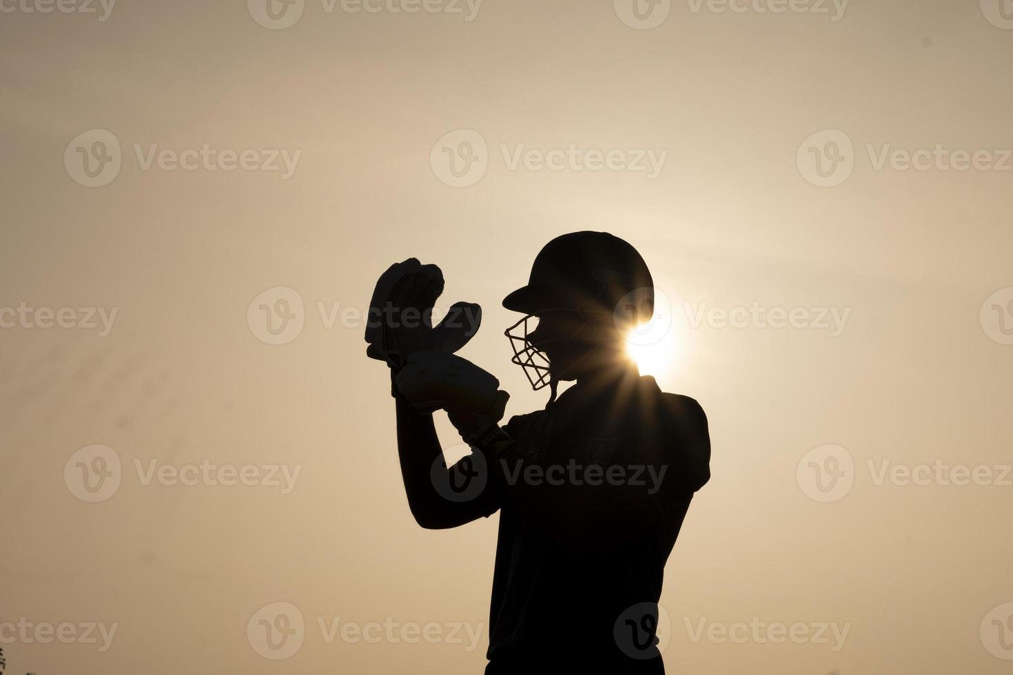 silhouet van een cricketspeler die zich 's avonds voor de wedstrijd klaarmaakt. Indiase cricket en sport concept. foto