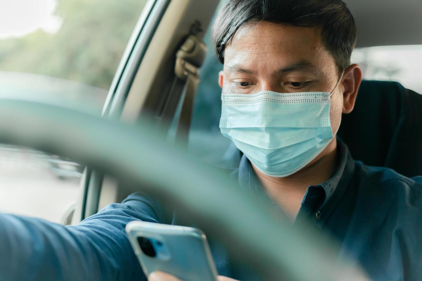 een man gebruikt zijn telefoon tijdens het rijden en valt in slaap tijdens het rijden. foto