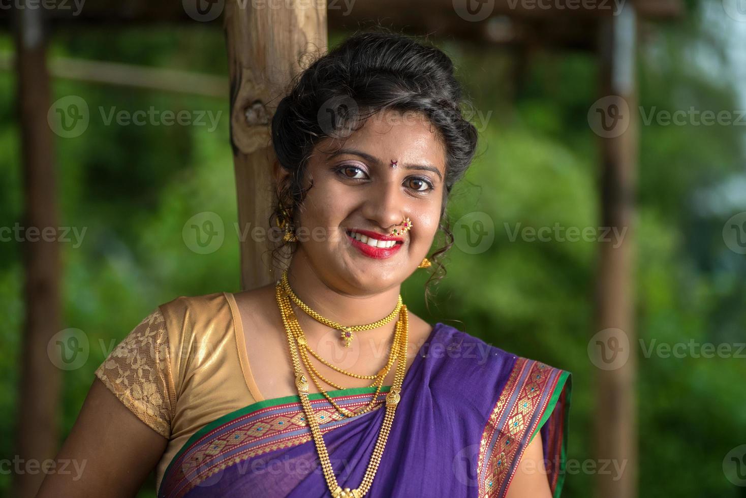 mooi Indisch jong meisje in traditionele saree die buitenshuis poseert foto