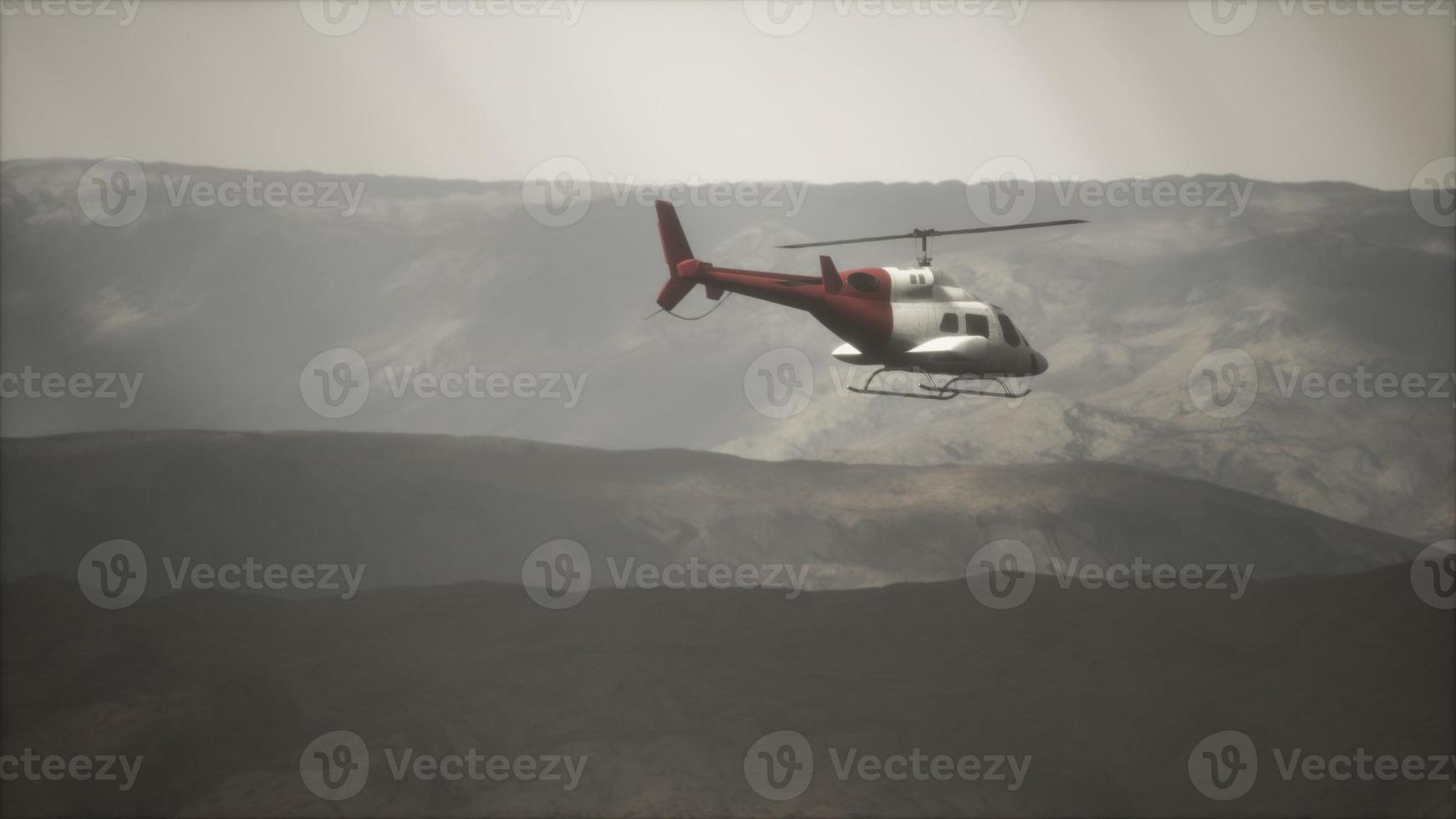 extreme slow motion vliegende helikopter in de buurt van bergen met mist foto