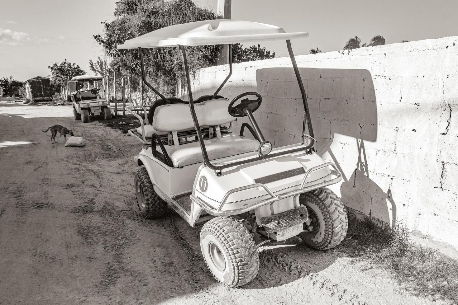 golfkar buggy auto's karren modderige straat dorp holbox mexico. foto