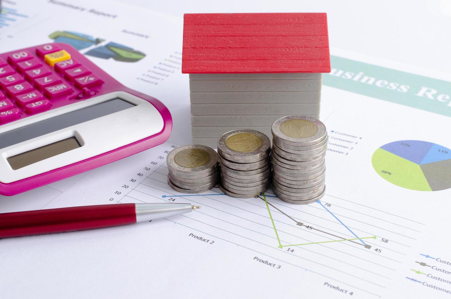 close up van geld munt stapel met rode huis en pen rekenmachine voor hypothecaire lening concept foto