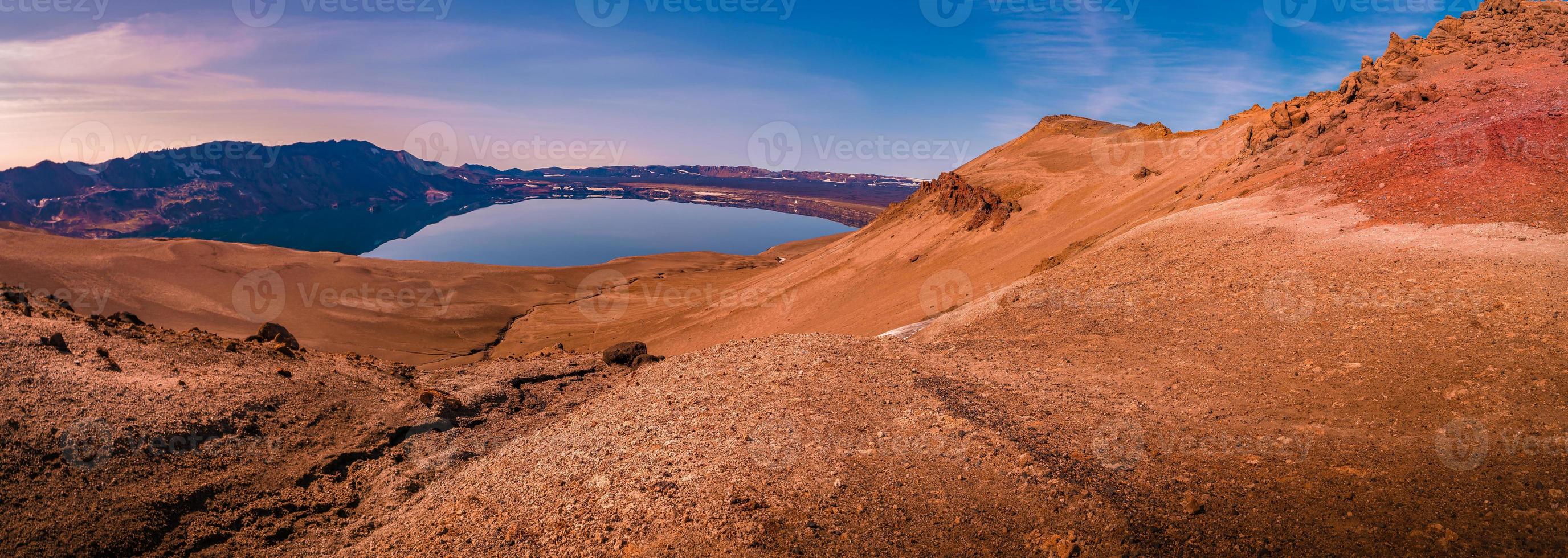 panoramisch uitzicht over het IJslandse landschap van de grote vulkanische caldera askja, midden in de vulkanische woestijn in de hooglanden, met rode, turquoise en oranje vulkaanbodem bij zonsondergangkleuren, ijsland. foto