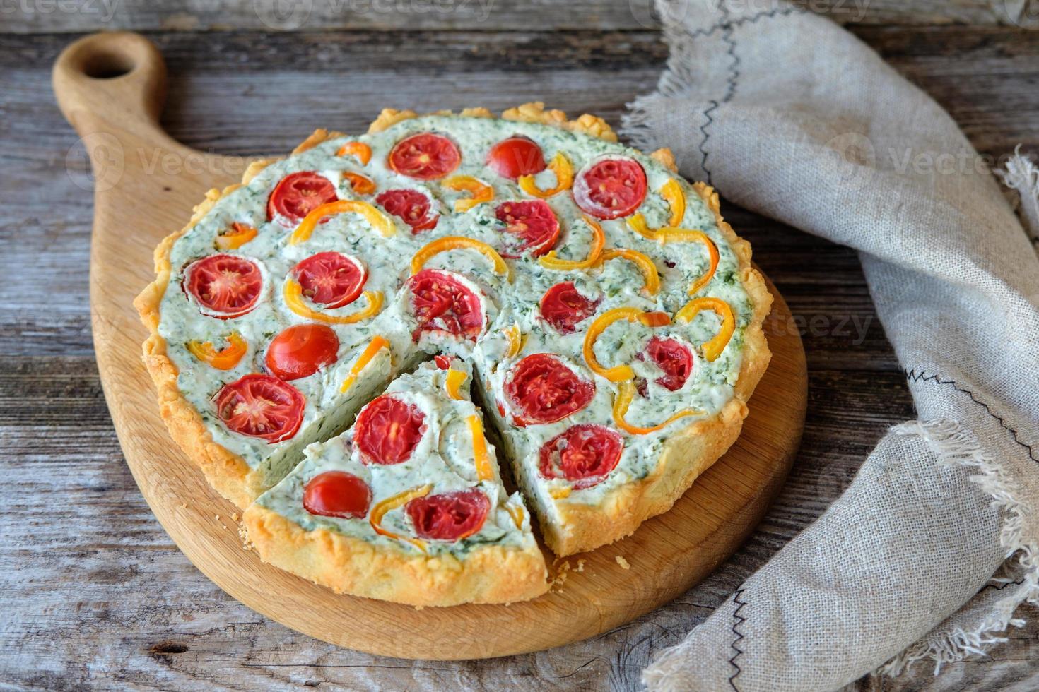 Franse quiche met tomaten en peper en broccoli op houten bord foto