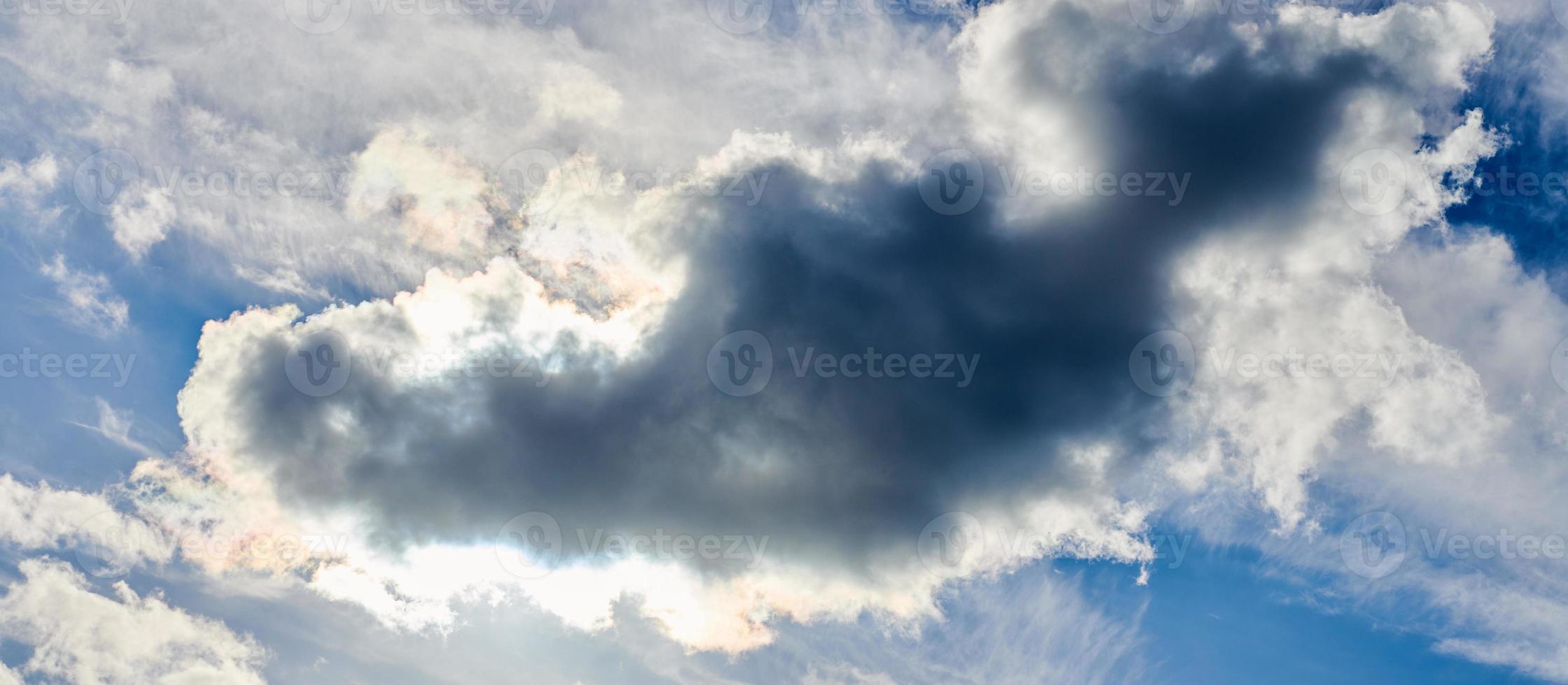 zon achter blauwe cumuluswolken, prachtig wolkenlandschap met zonneschijn van achter wolken op blauwe lucht foto