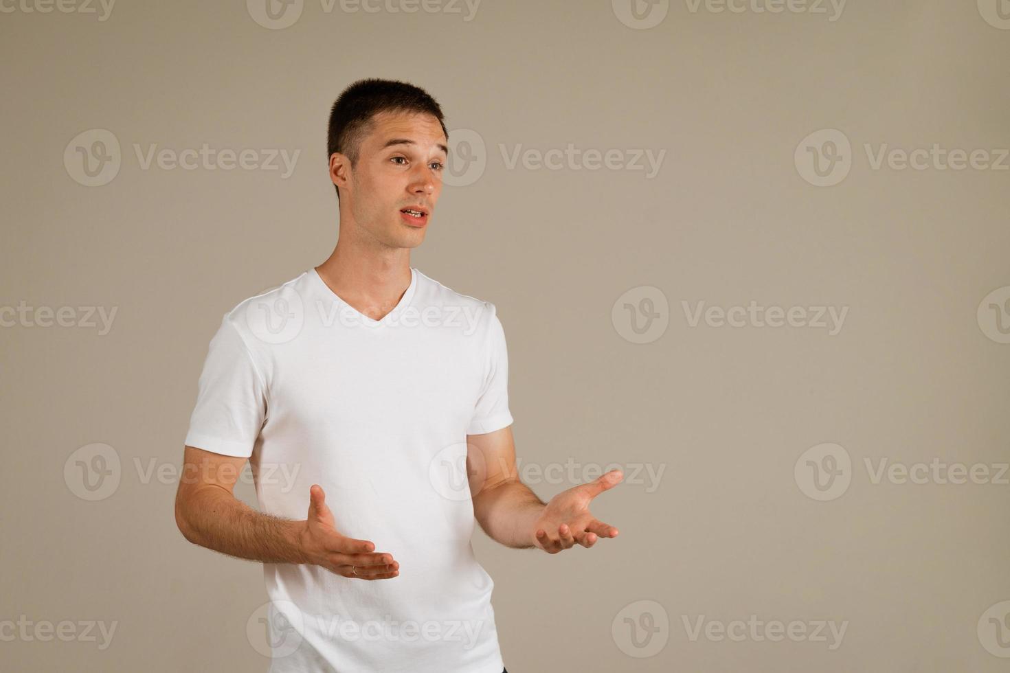 man in een wit t-shirt gebaren tegen de achtergrond foto
