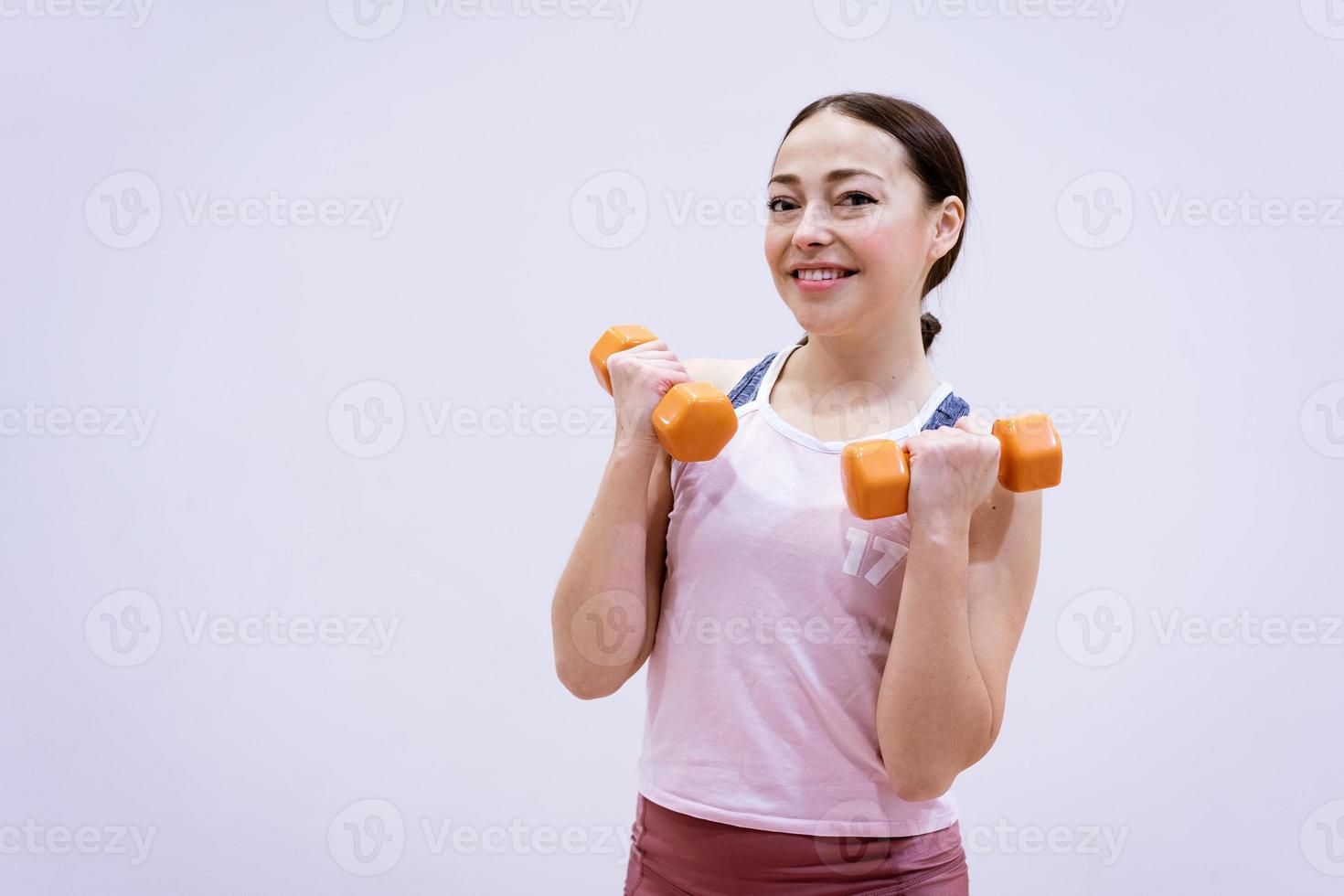 vrouw in sportkleding houdt zich bezig met halters foto
