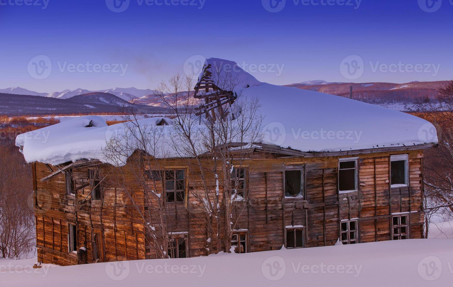 oud lelijk vervallen houten huis op de zonsondergang foto