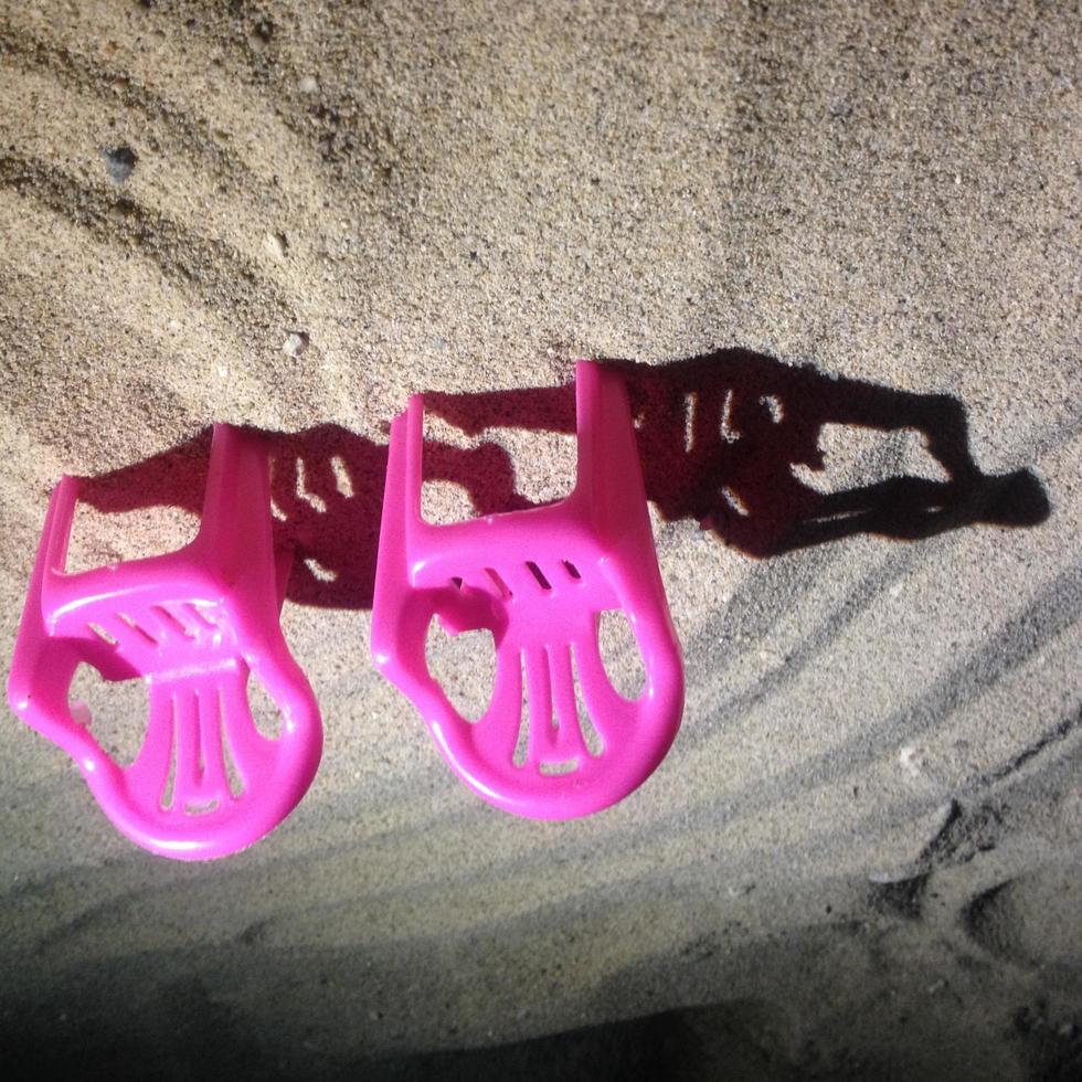 miniatuur roze stoelen op het strandzand foto
