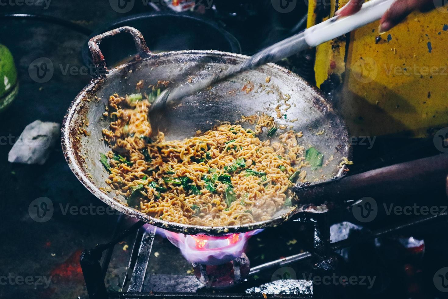 koken instant noedels of mie dok dok of mie in de pan. Indonesische noedelsoep gemaakt van gefrituurde instant noedels met jus ei, groenten en crackers foto