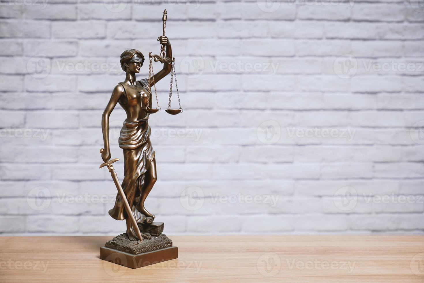 Vrouwe Justitia of Justitia het standbeeld van de godin van Justitie op het bureau - juridische wet wetgeving concept foto