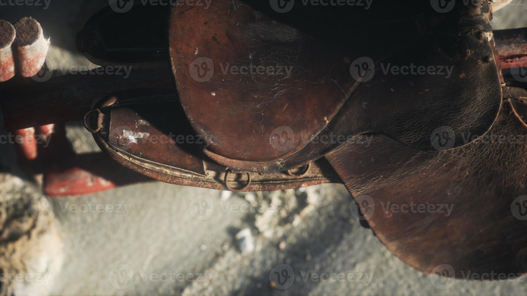 lederen zadel op hek in woestijn 5754704 Stockfoto