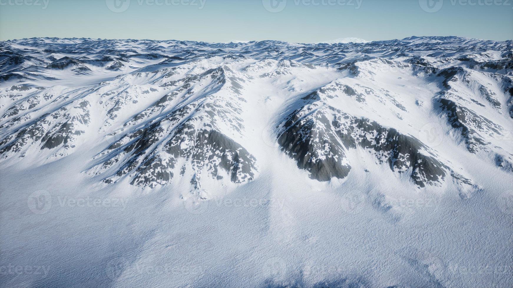 8k luchtlandschap van besneeuwde bergen en ijzige kusten in antarctica foto