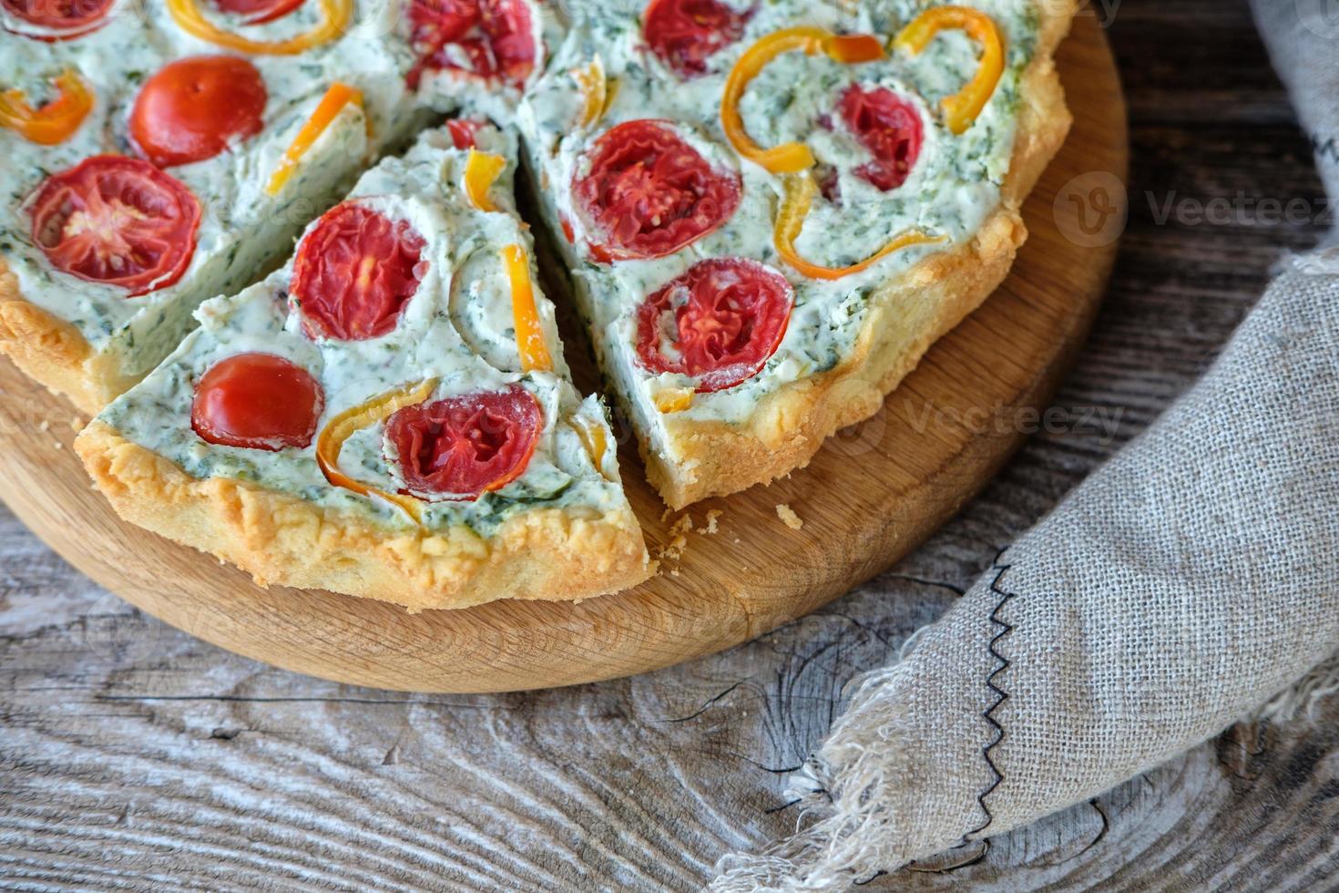 Franse quiche met tomaten en peper en broccoli op houten bord foto