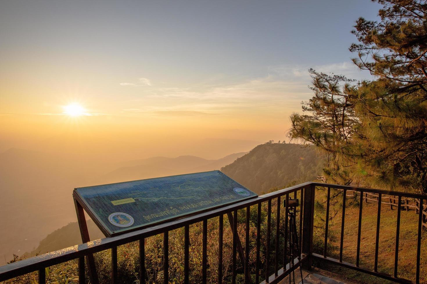 loei provincie, thailand december 2021 phu ruea nationaal park plaats bord met achtergrond van ochtendzonsopgang en prachtige vallei bij uitkijkpunt bovenop phu ruea nationaal park. foto