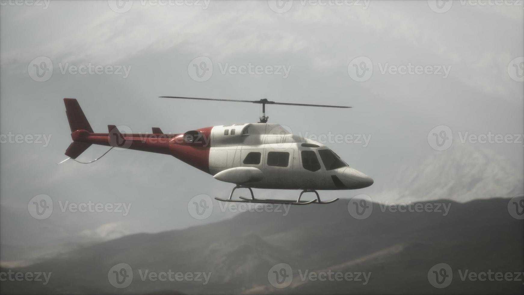 extreme slow motion vliegende helikopter in de buurt van bergen met mist foto