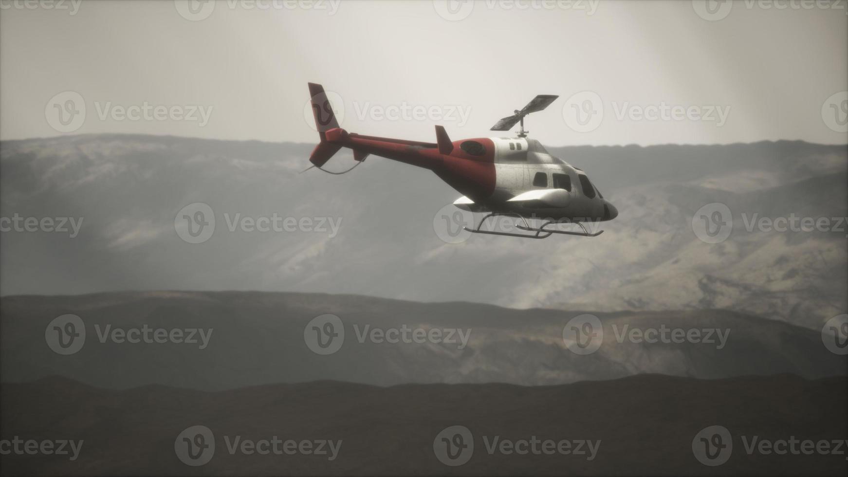 extreme slow motion vliegende helikopter in de buurt van bergen met mist foto