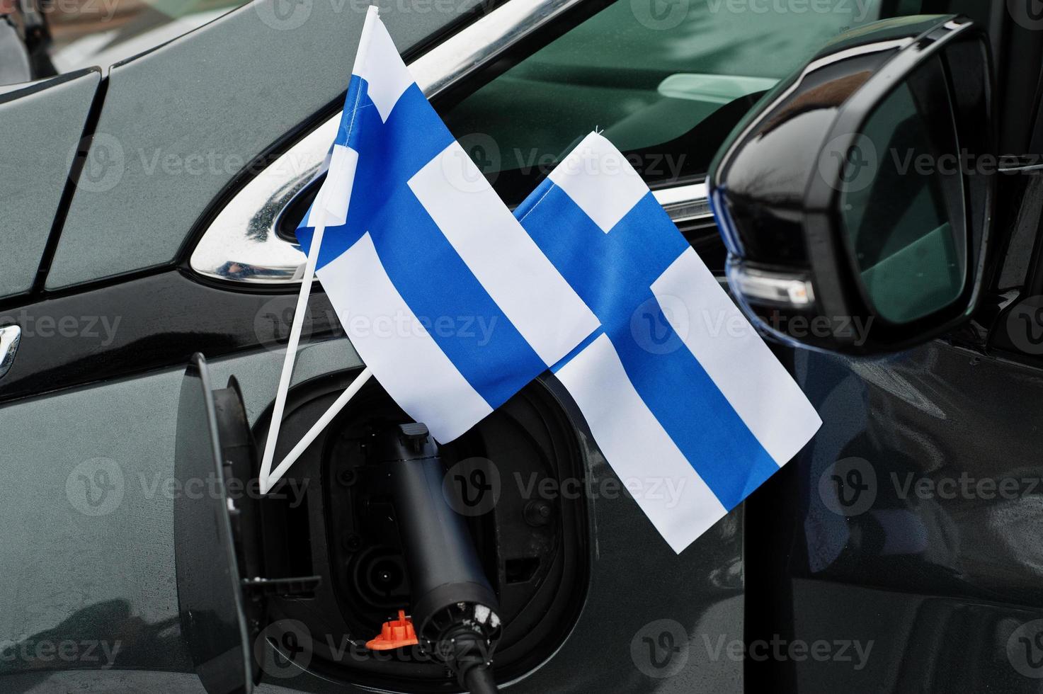 finland vlag ecologisch autoconcept. een stroomleverancier aansluiten, moderne auto's opladen. foto