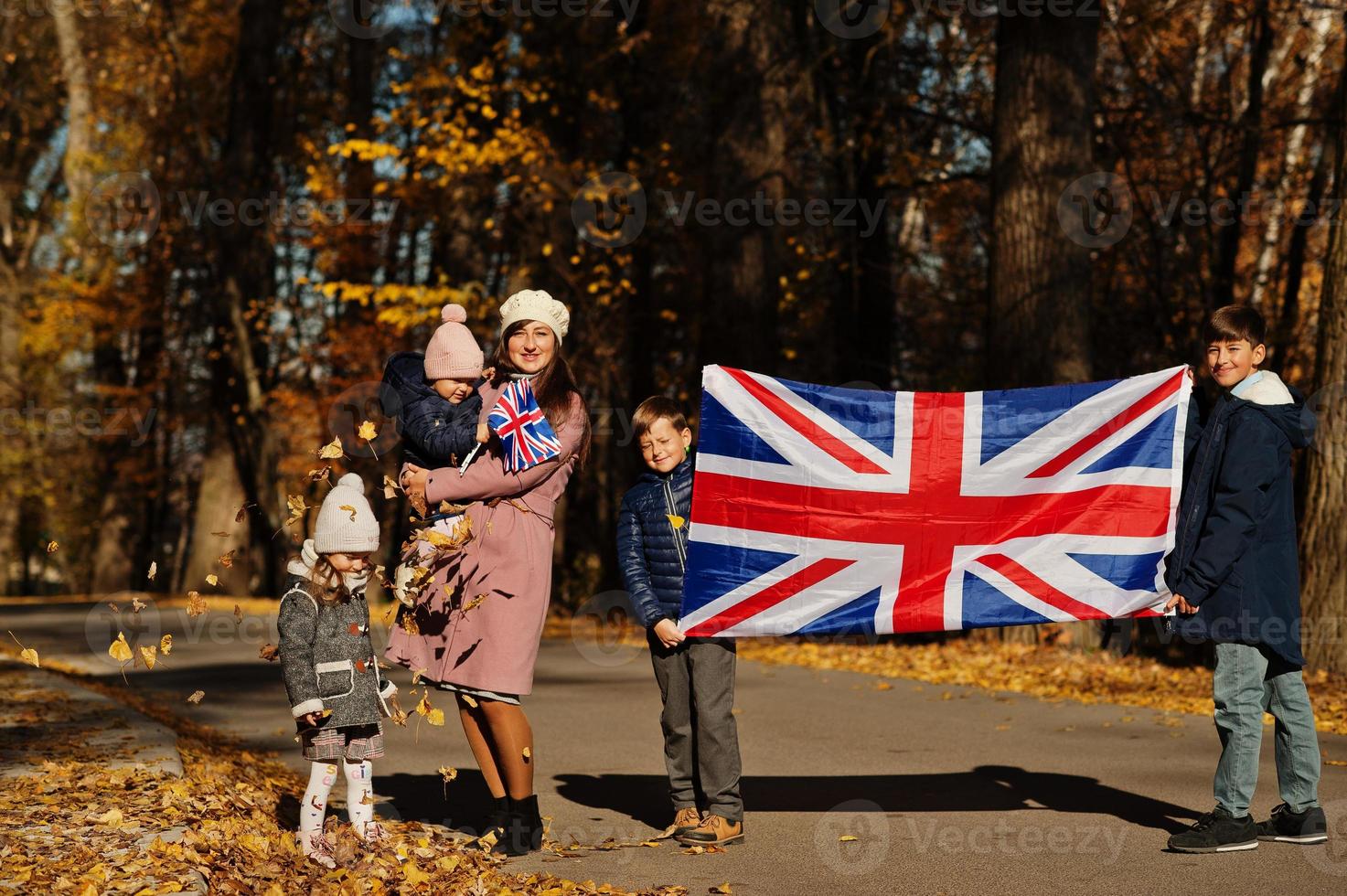 nationale feestdag van het verenigd koninkrijk. familie met britse vlaggen in herfst park. britse vieren uk. moeder met vier kinderen. foto