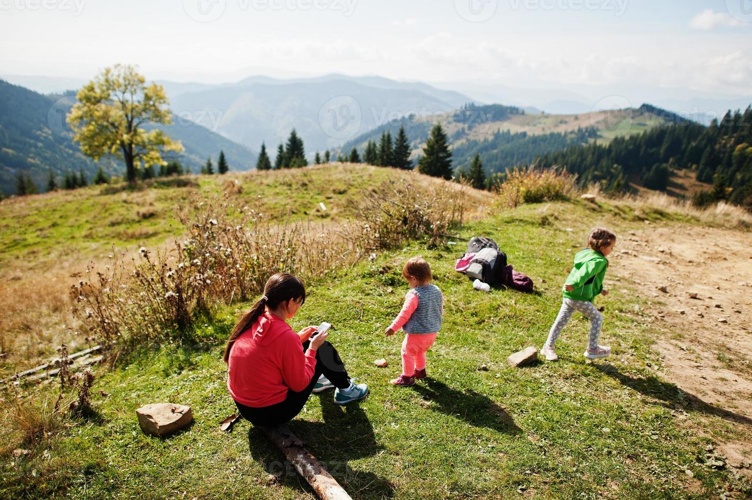 moeder met dochters die genieten in de bergen. Het concept van familiereizen, avontuur en toerisme. levensstijl en wandelen herfstvakanties buiten. foto