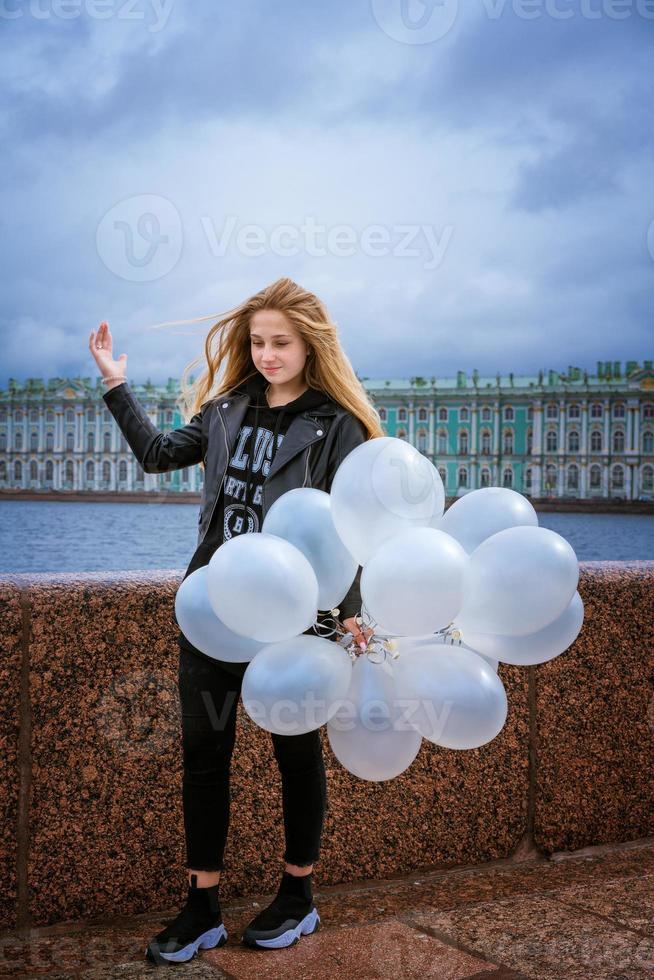 gelukkig vrolijk meisje met plezier met grote witte latex ballonnen. buiten op de foto