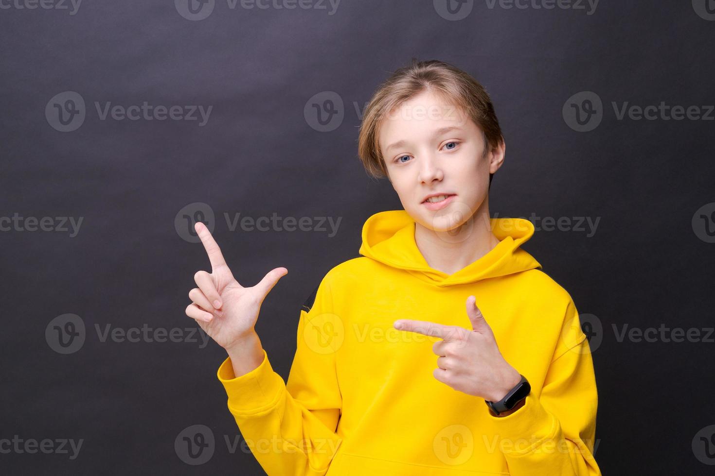 gelukkig vrolijk lachende jonge blanke man met blond haar, gekleed in een gele foto