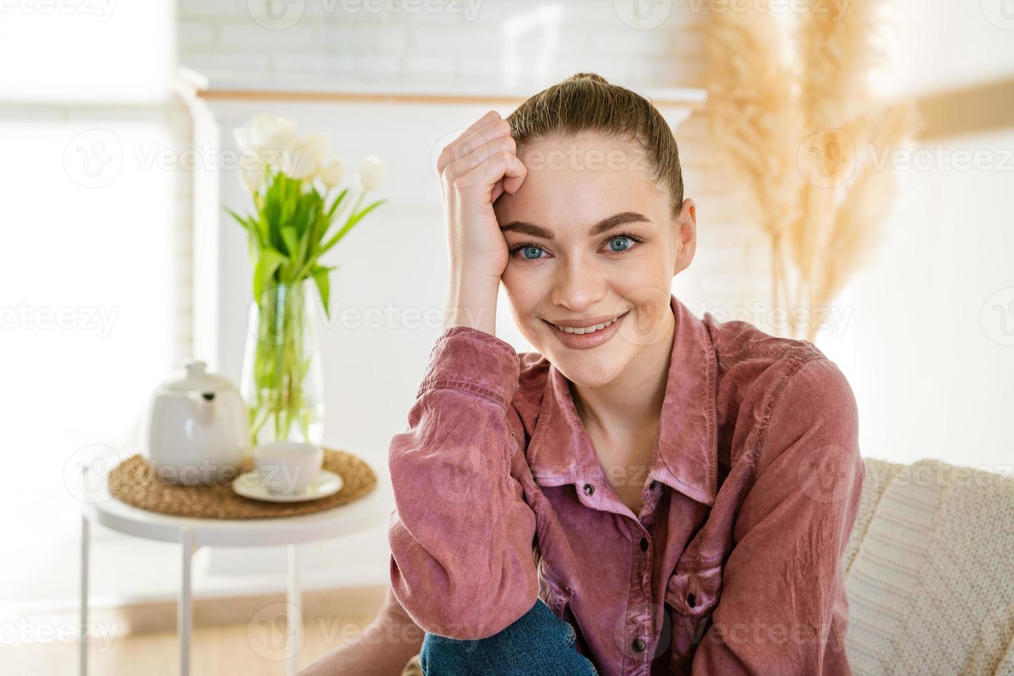 kalme jonge blanke vrouw zittend op een comfortabele stoel en genietend foto