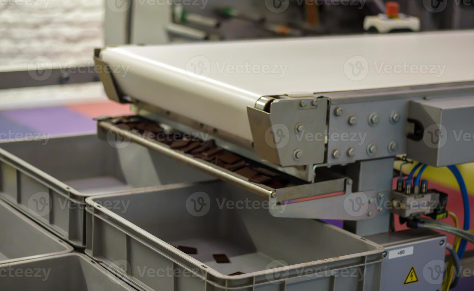 lijn voor de productie van chocolade in een industriële fabriek. automatisch proces in de productielijn van snoep. beelden van de chocoladefabriek tijdens de productie. transportband met snoep. foto