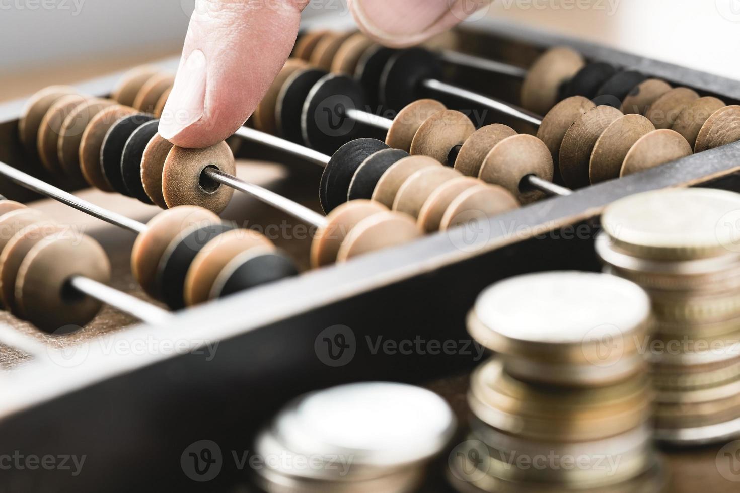 close-up van een mannelijke vinger die geld telt met behulp van vintage houten telraam foto