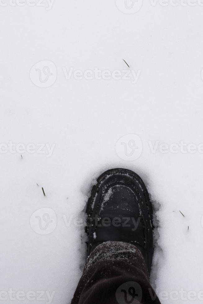 mannelijke voet stapt in verse sneeuw foto