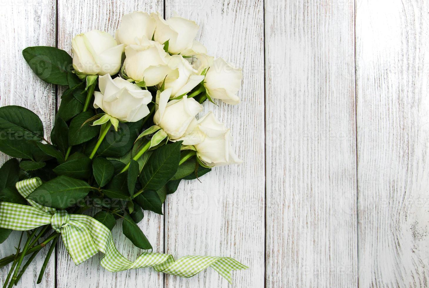 witte rozen op een houten tafel foto