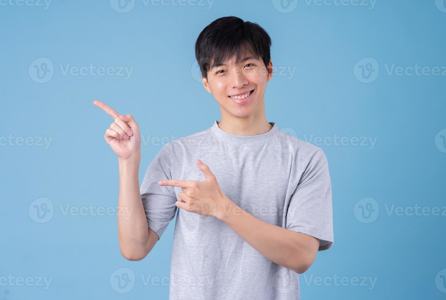 jonge Aziatische man die zich voordeed op blauwe achtergrond foto