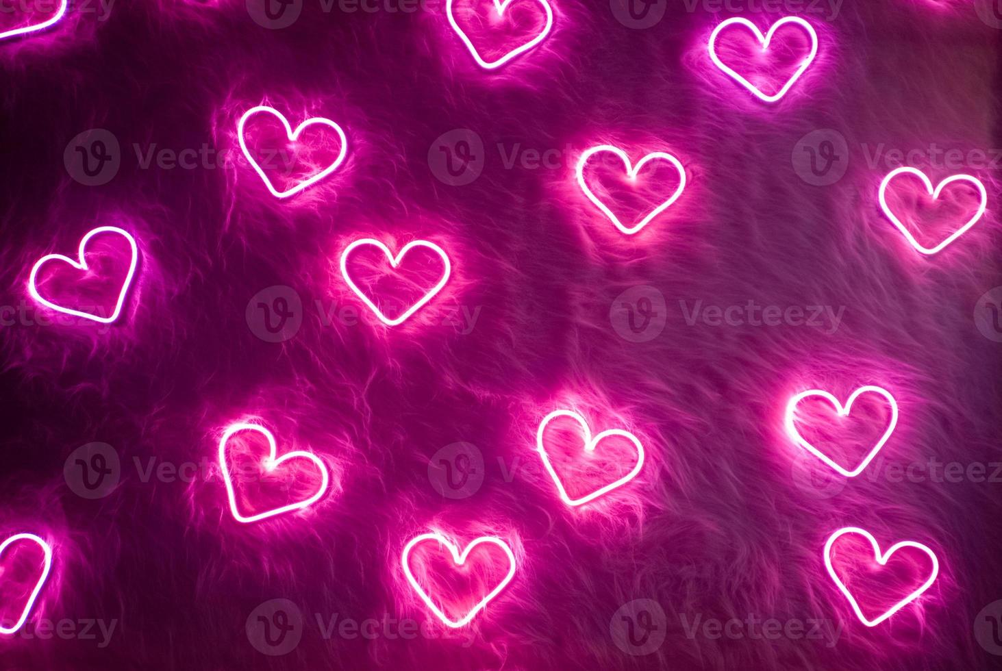 Valentijnsdag achtergrond. neon roze hart op witte vacht. foto