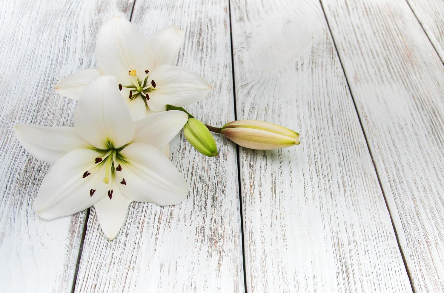 witte lelies op een houten tafel foto