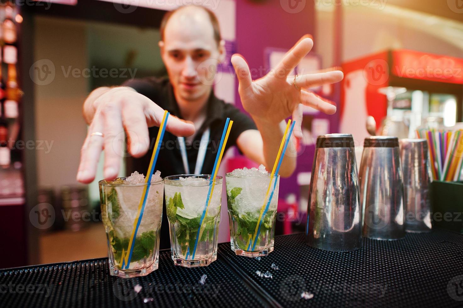 barman die mojito-cocktaildrank aan de bar bereidt foto