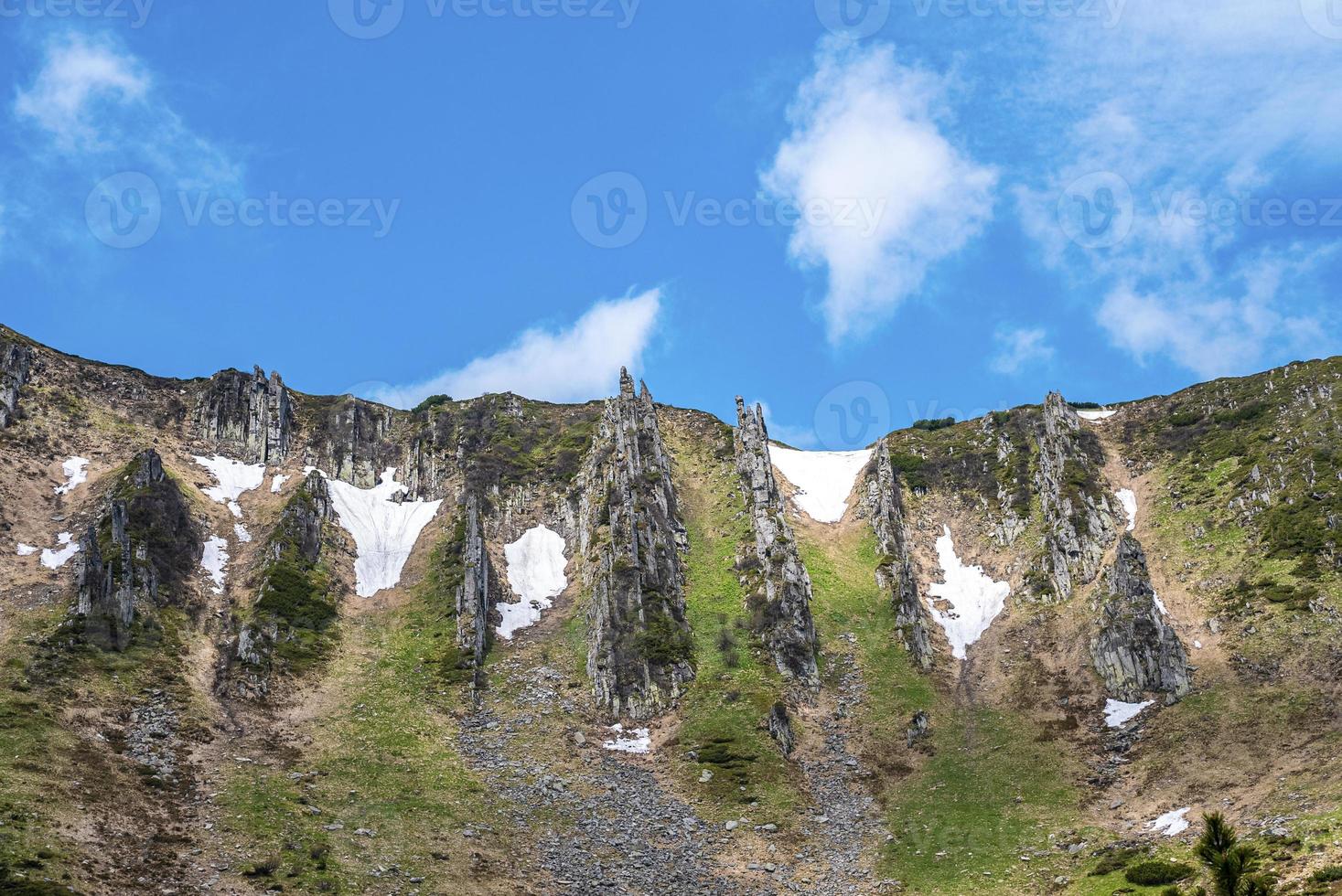 lage hoekmening van rotsklif bedekt met mos en sneeuw en lucht foto