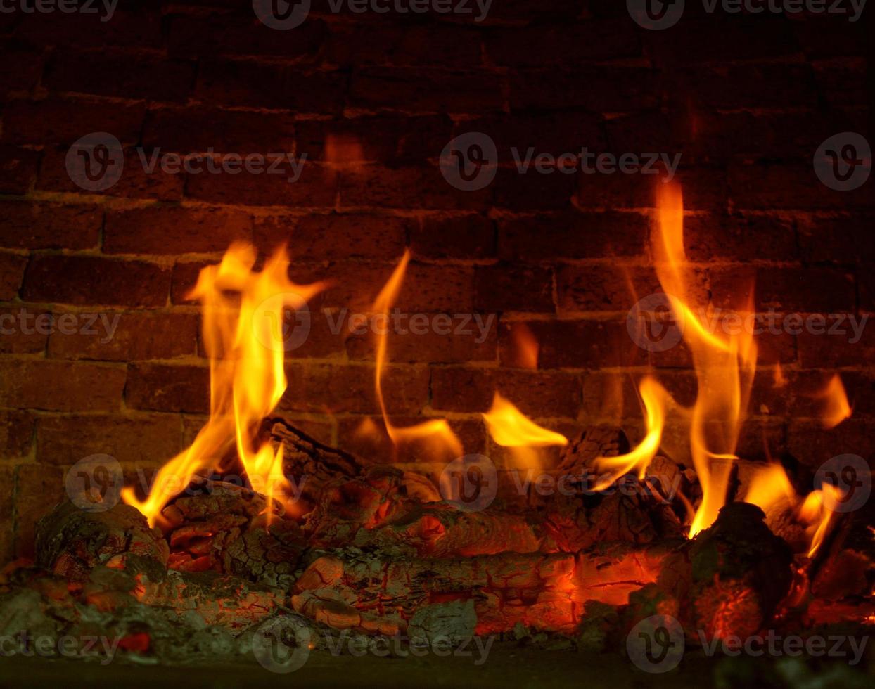 brandhout en sintels. de laaiende vlammen van de vuurvlammen in de open haard. foto