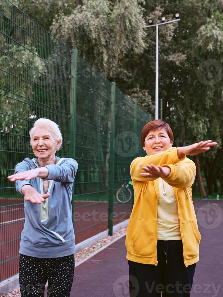 twee volwassen vrouwen die sportoefeningen doen in het park. gezond levensstijlconcept foto
