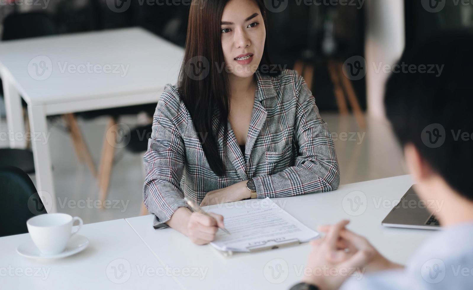 sollicitatiegesprek concept. zakenman vragen stellen en luisteren naar antwoorden van kandidaten tijdens het interview. foto