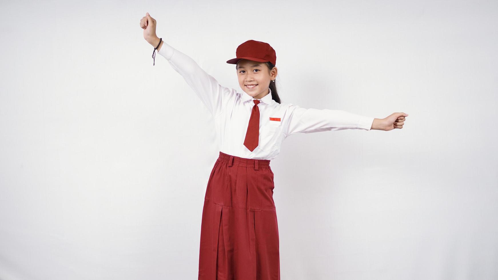 Vrij gelukkig basisschoolmeisje dat op witte achtergrond wordt geïsoleerd foto