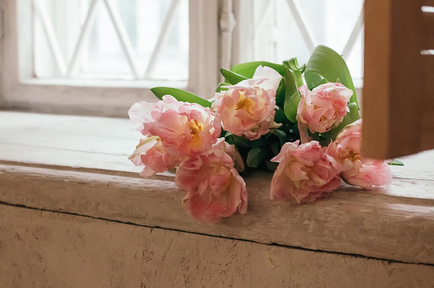 zacht gerichte roze pioen bloemen op witte vensterbank foto