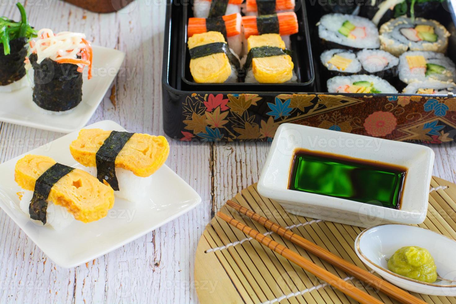 set van verschillende sushi op witte plaat en bento box geserveerd met sojasaus en wasabi. heerlijk Japans eten. foto