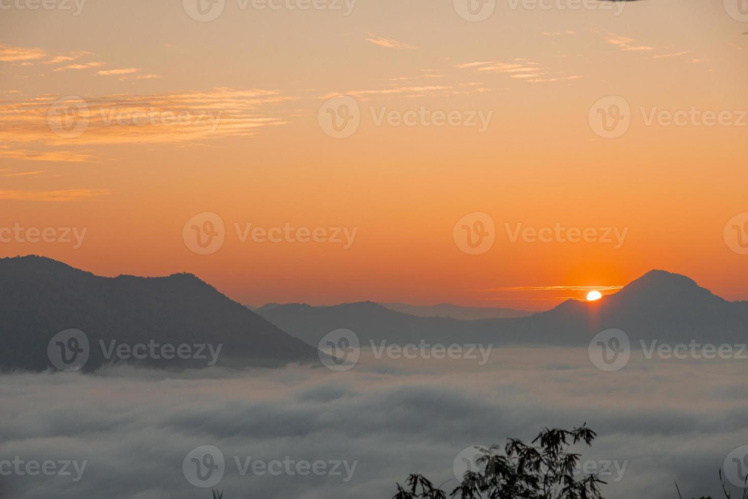 zeemist en gouden zonsopgang bestrijken het gebied op de top van de heuvel doi phu thok, chiang khan, loei, thailand met een achtergrond van zonsopgang in de winter. foto