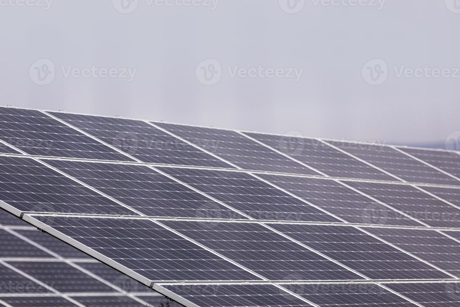 een elektriciteitscentrale die gebruik maakt van hernieuwbare zonne-energie met de zon. zonnecellen of fotovoltaïsche cellen in het station van de zonne-energiecentrale verschijnen hemelwaarts en absorberen het zonlicht van de zon. close-up van de foto. foto