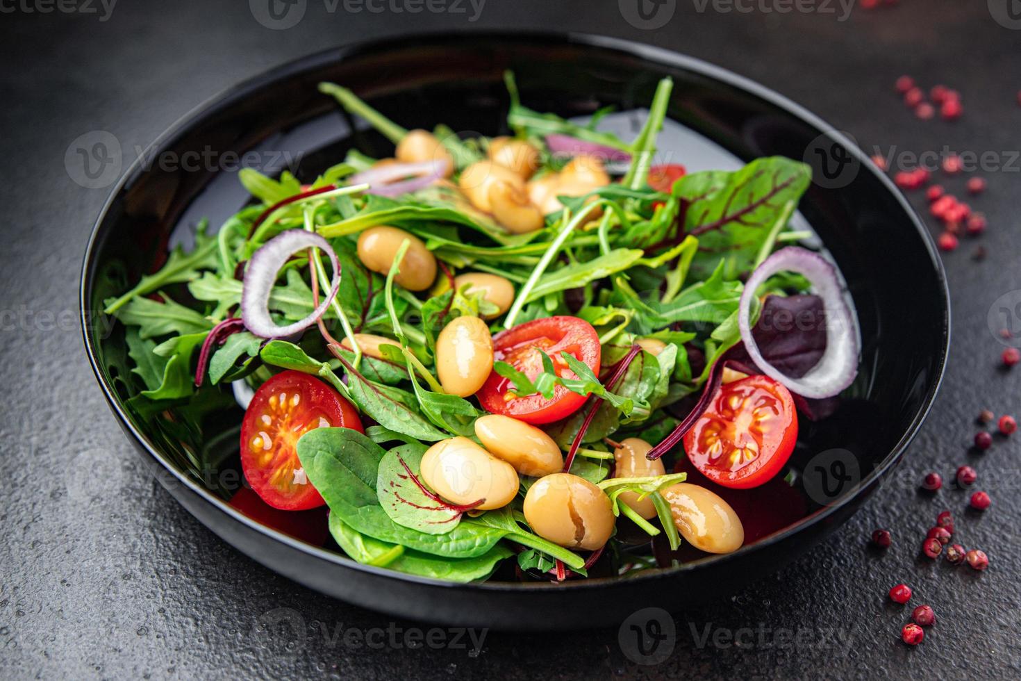 salade witte bonen, tomaat, blaadjes sla mix bloemblaadjes verse portie gezonde maaltijd eten foto