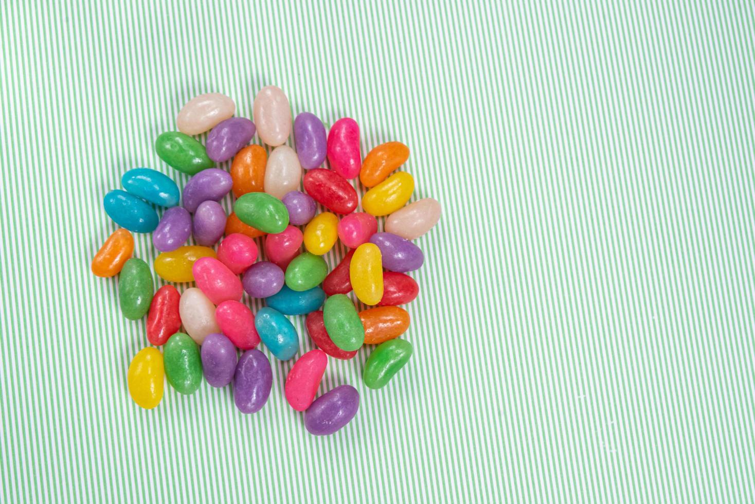 verschillende jelly beans over groen gestreepte achtergrond met wit foto