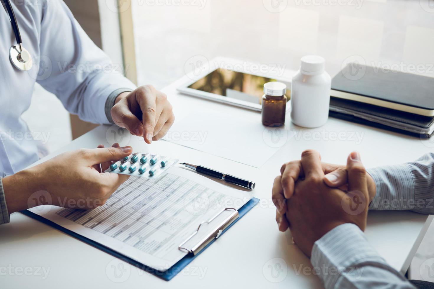 arts houdt een medicijnpaneel vast om advies te geven over het gebruik van medicijnen voor de behandeling van tumoren op kantoor. foto