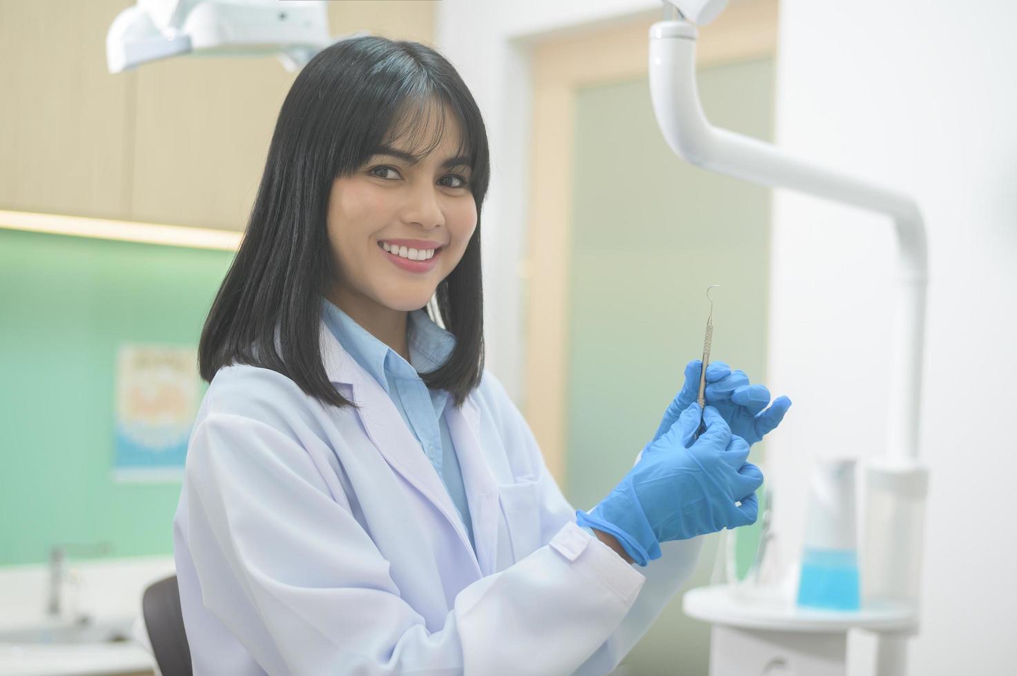 portret van vrouwelijke tandarts die in de tandheelkundige kliniek werkt, tandencontrole en gezond gebit concept foto
